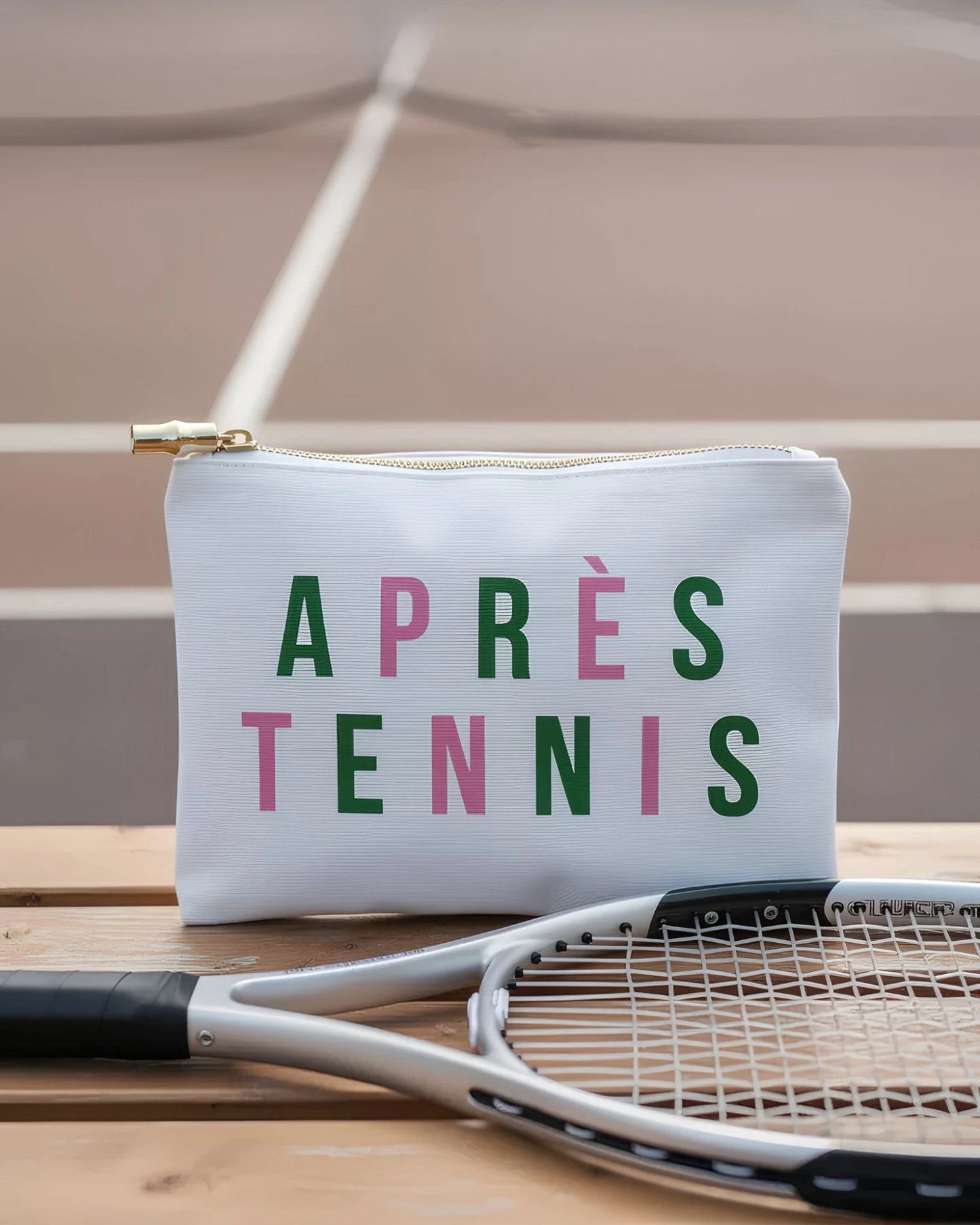 White pouch with 'APRèS TENNIS' text on a tennis court