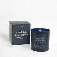 A scented candle labeled 'A Midnight Stroll in Paris' with a blue hue, alongside its packaging box which has the same labeling.