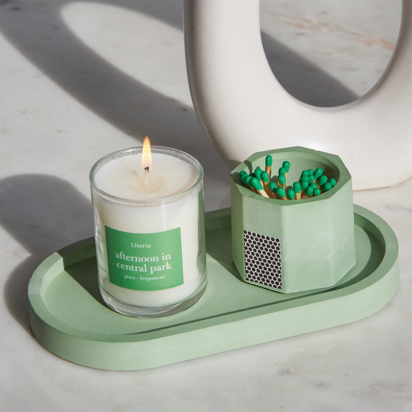 Matcha green pill shaped candle tray with green candle and green matchsticks.