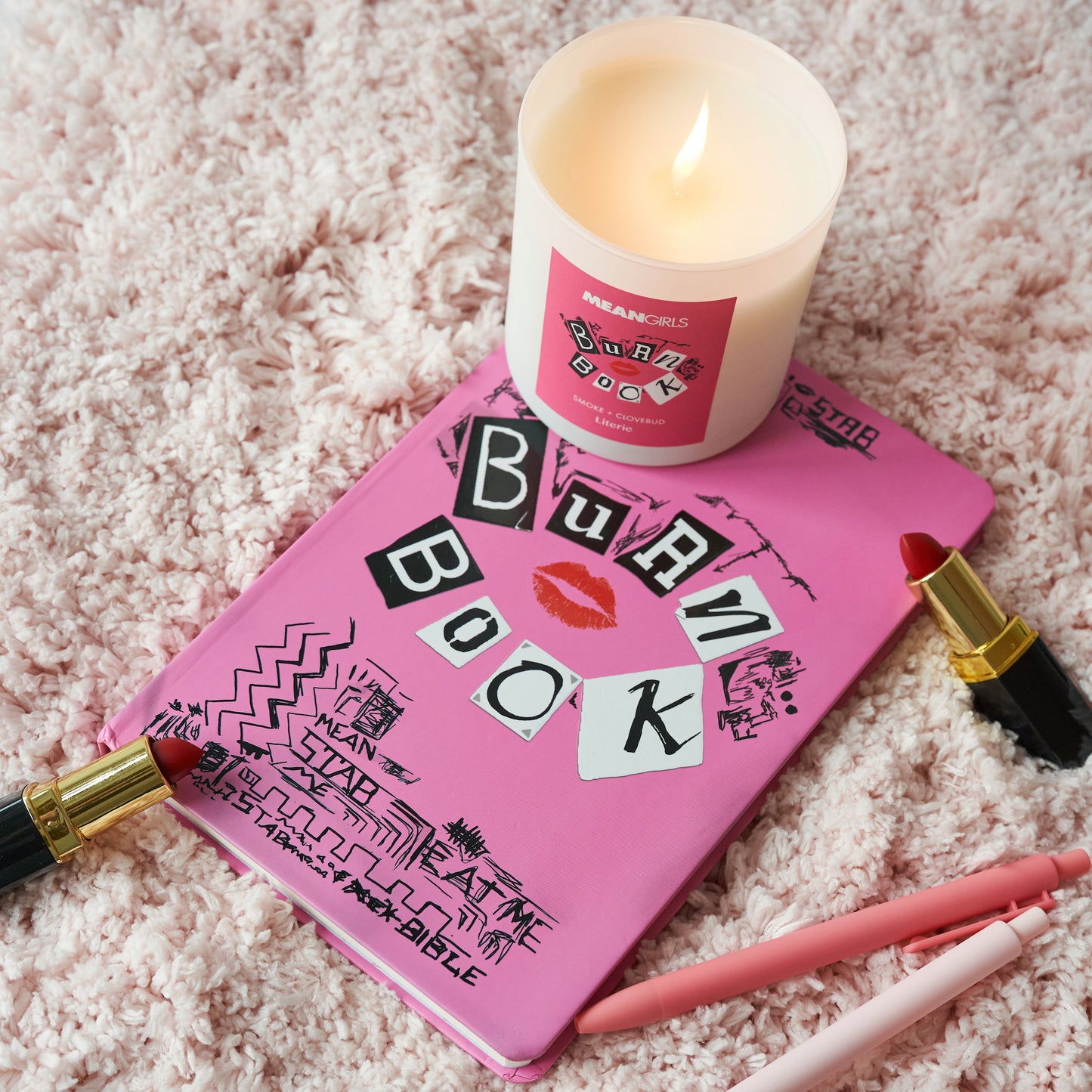 Burn Book Mean Girls candle on top of the actual Burn Book.