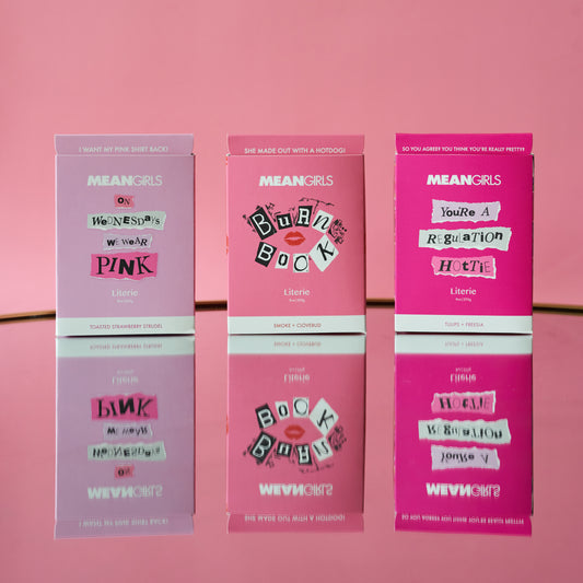 Three candle packages themed after the movie 'Mean Girls', with pink packaging and popular phrases from the film.