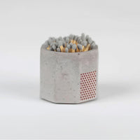 Grey concrete match stick holder with matches.