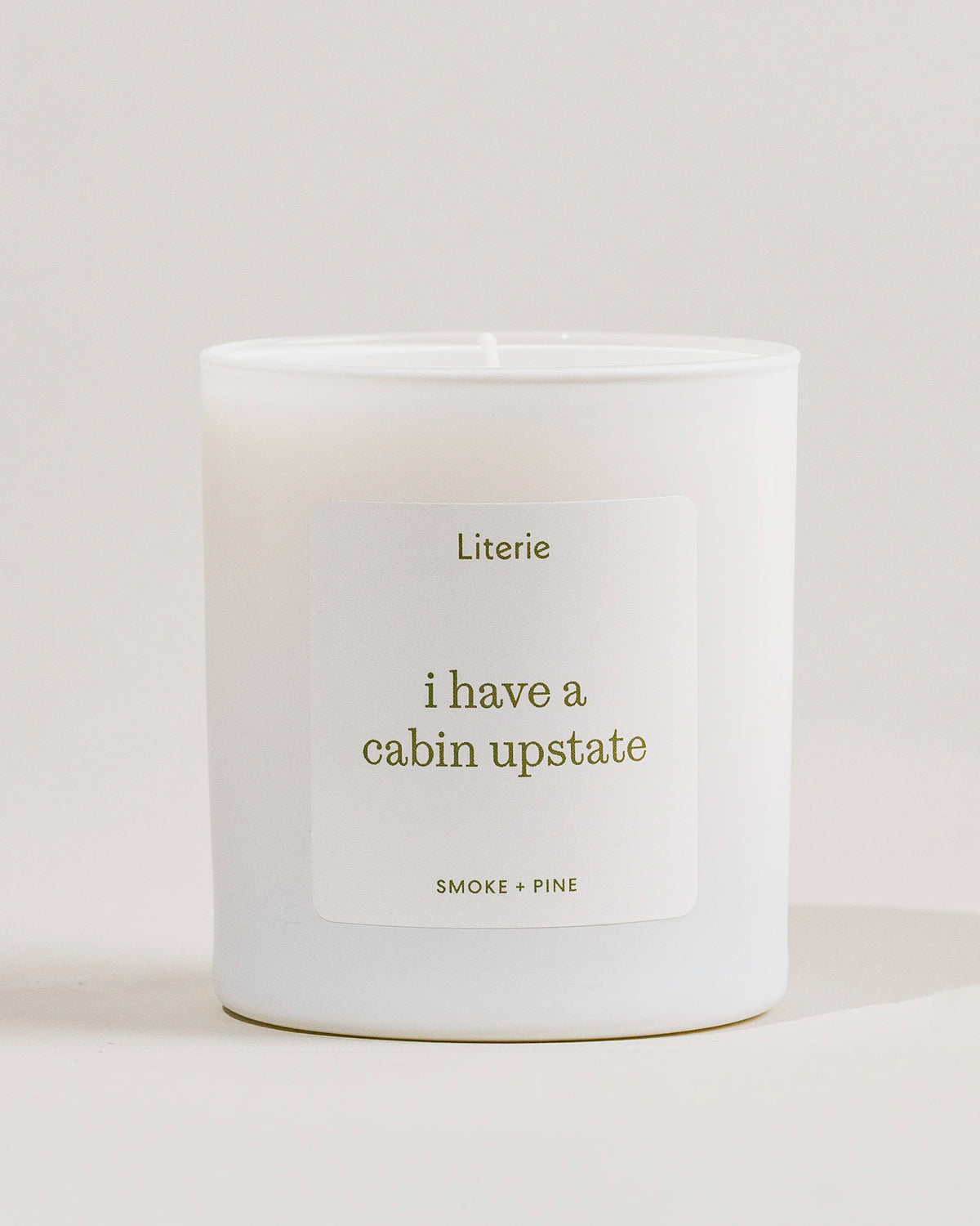 White 'i have a cabin upstate'c andle with a label on a light gray background