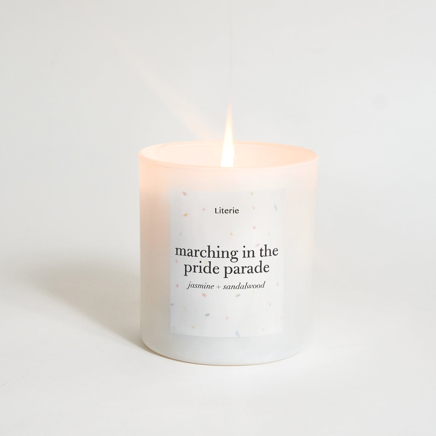Candle with text 'marching in the pride parade' on a light background