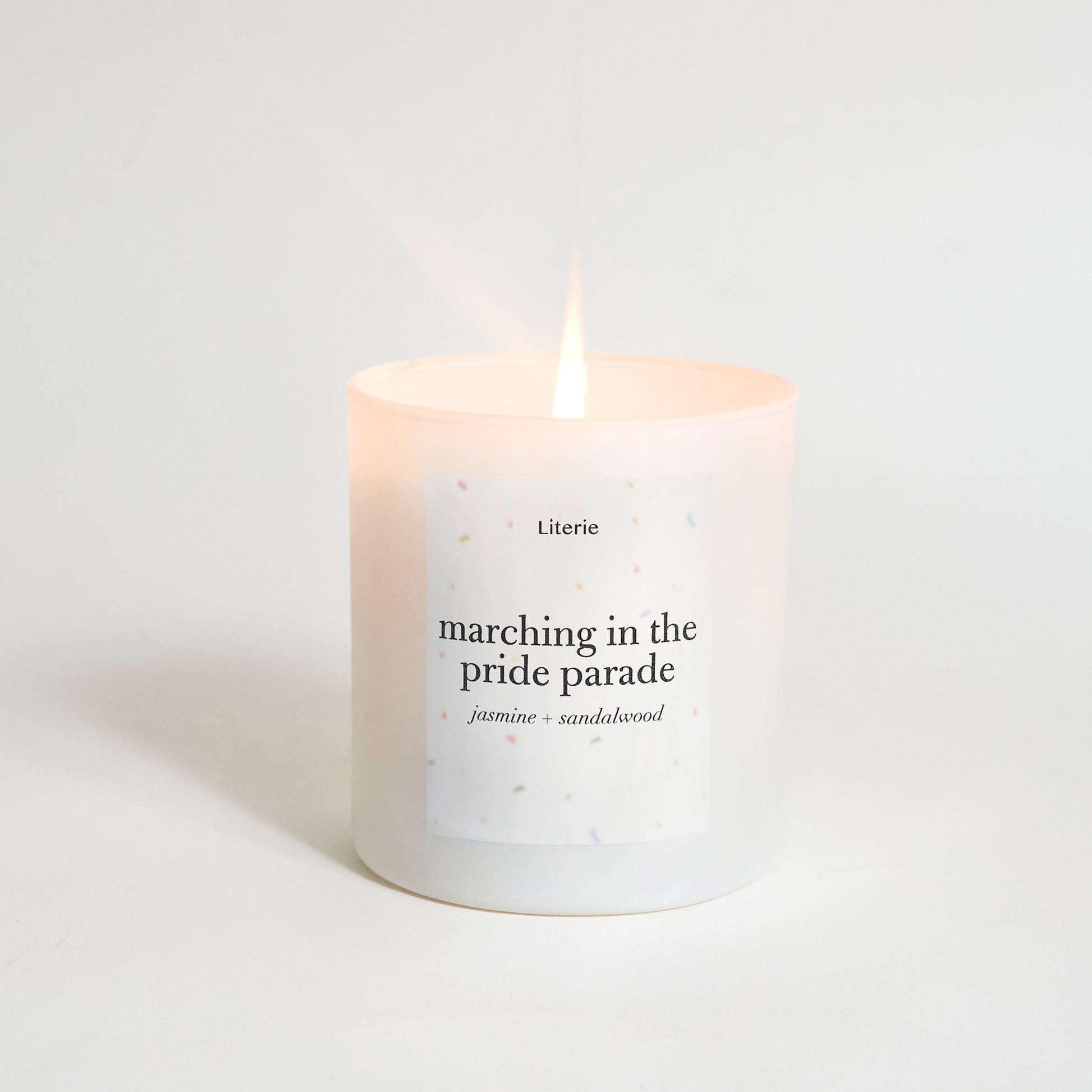 Candle with text 'marching in the pride parade' on a light background