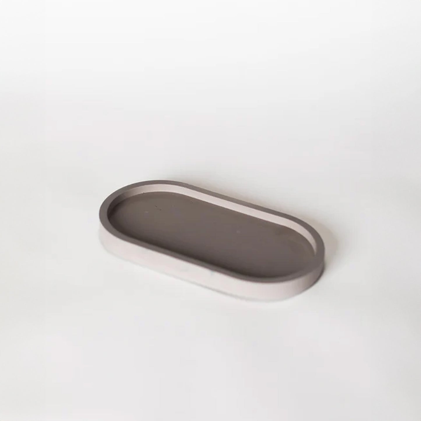 Grey pill shaped candle tray.
