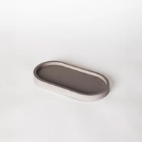 Grey pill shaped candle tray.