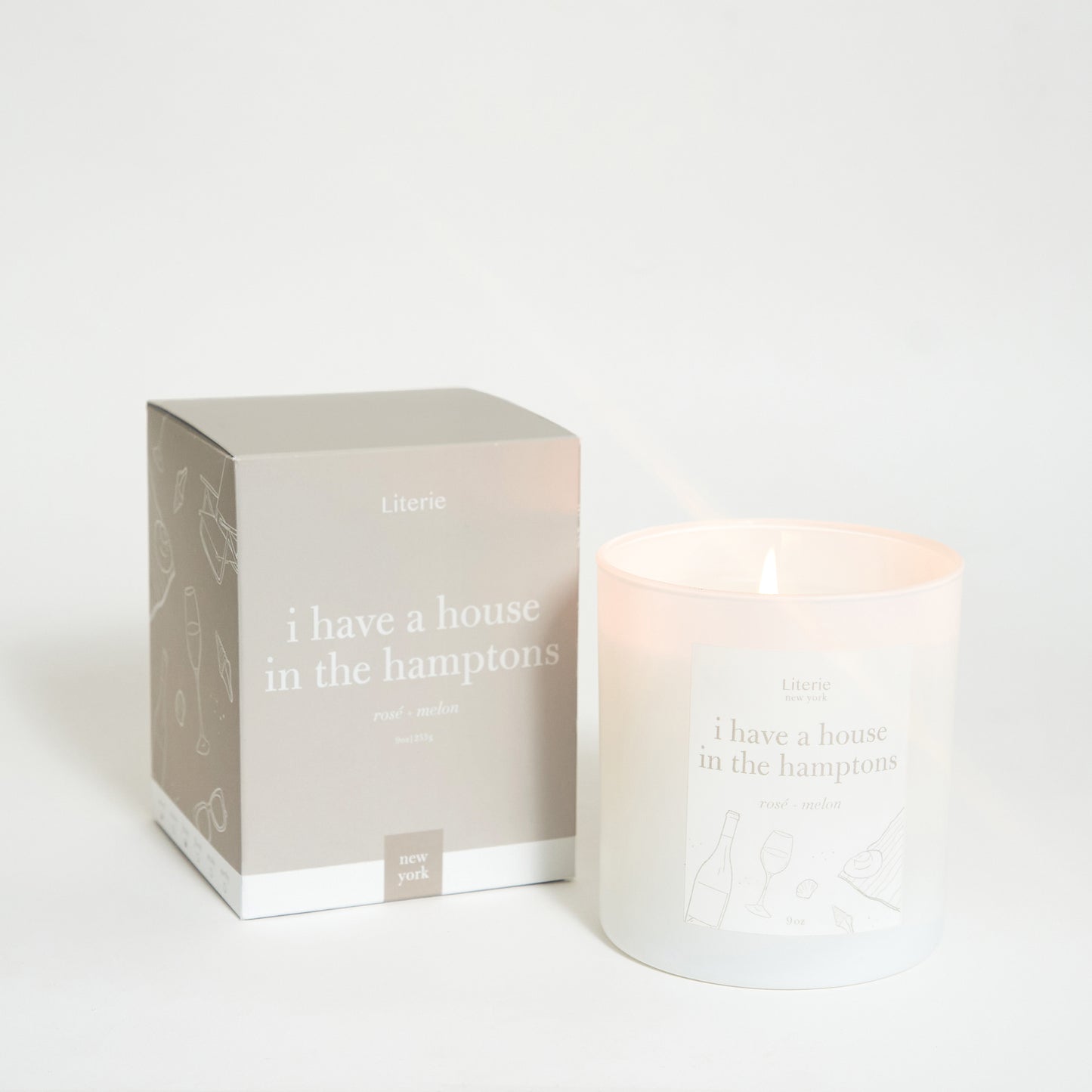 A scented candle with its packaging box, the box has text 'I have a house in the hamptons' written on it, and the candle is labeled similarly.