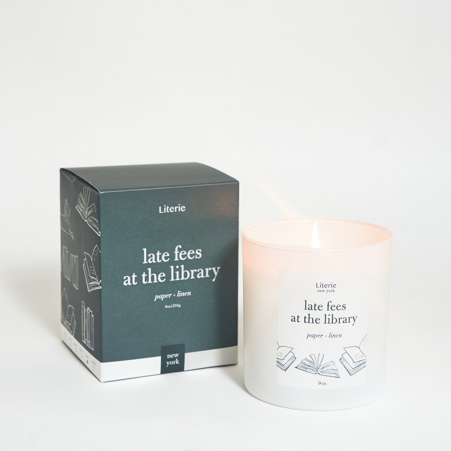A candle with a label 'late fees at the library' beside its packaging box which has similar labeling.