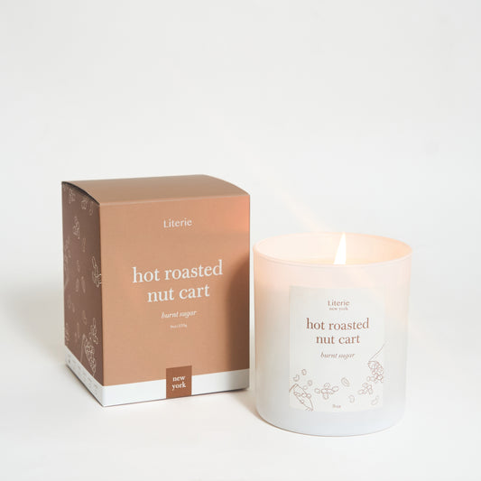 A candle labeled 'hot roasted nut cart' with a matching box, both featuring a minimalist design.