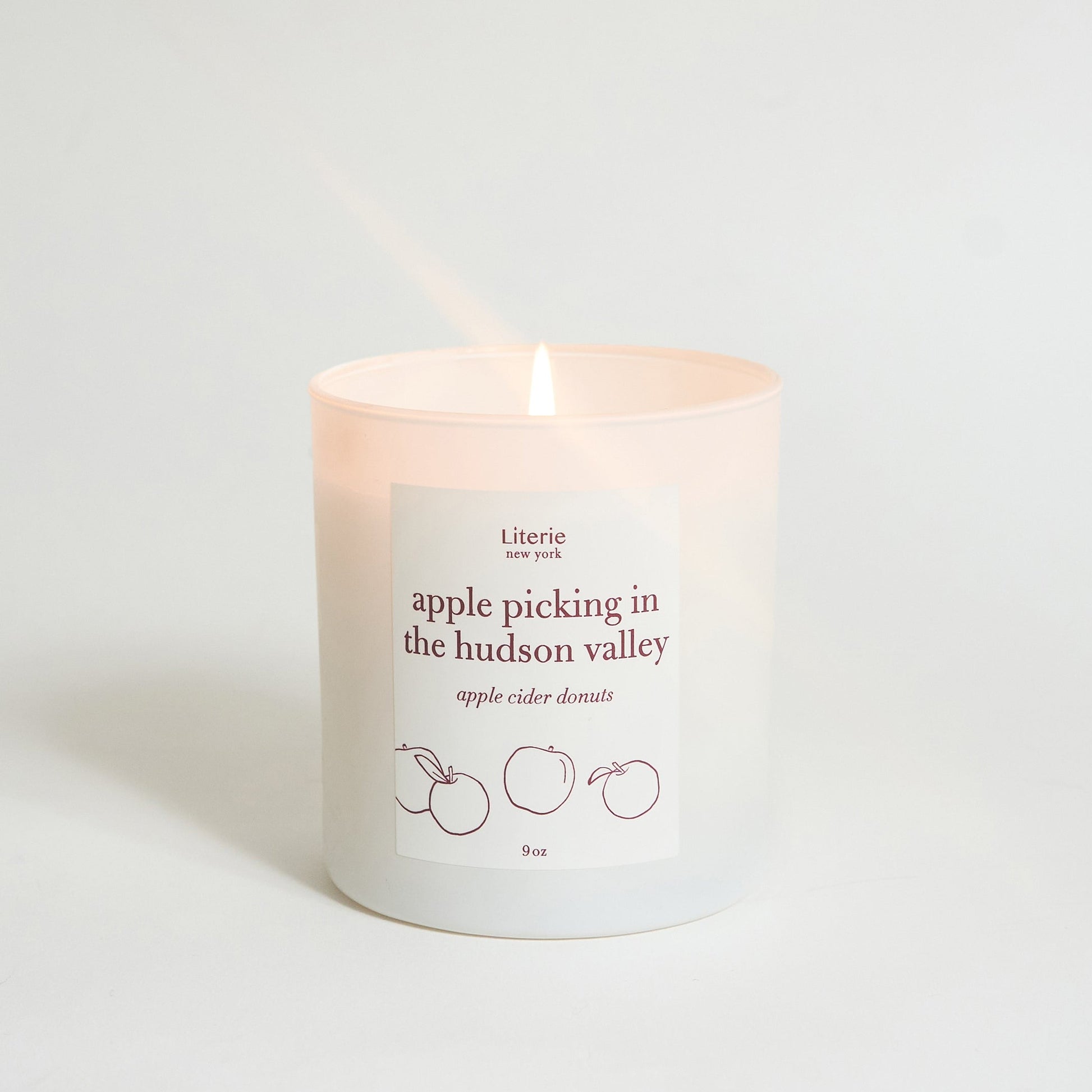 Apple picking in the hudson valley candle on white background.