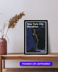 Framed New York City Marathon poster on a wooden shelf with a vase and dried plants.