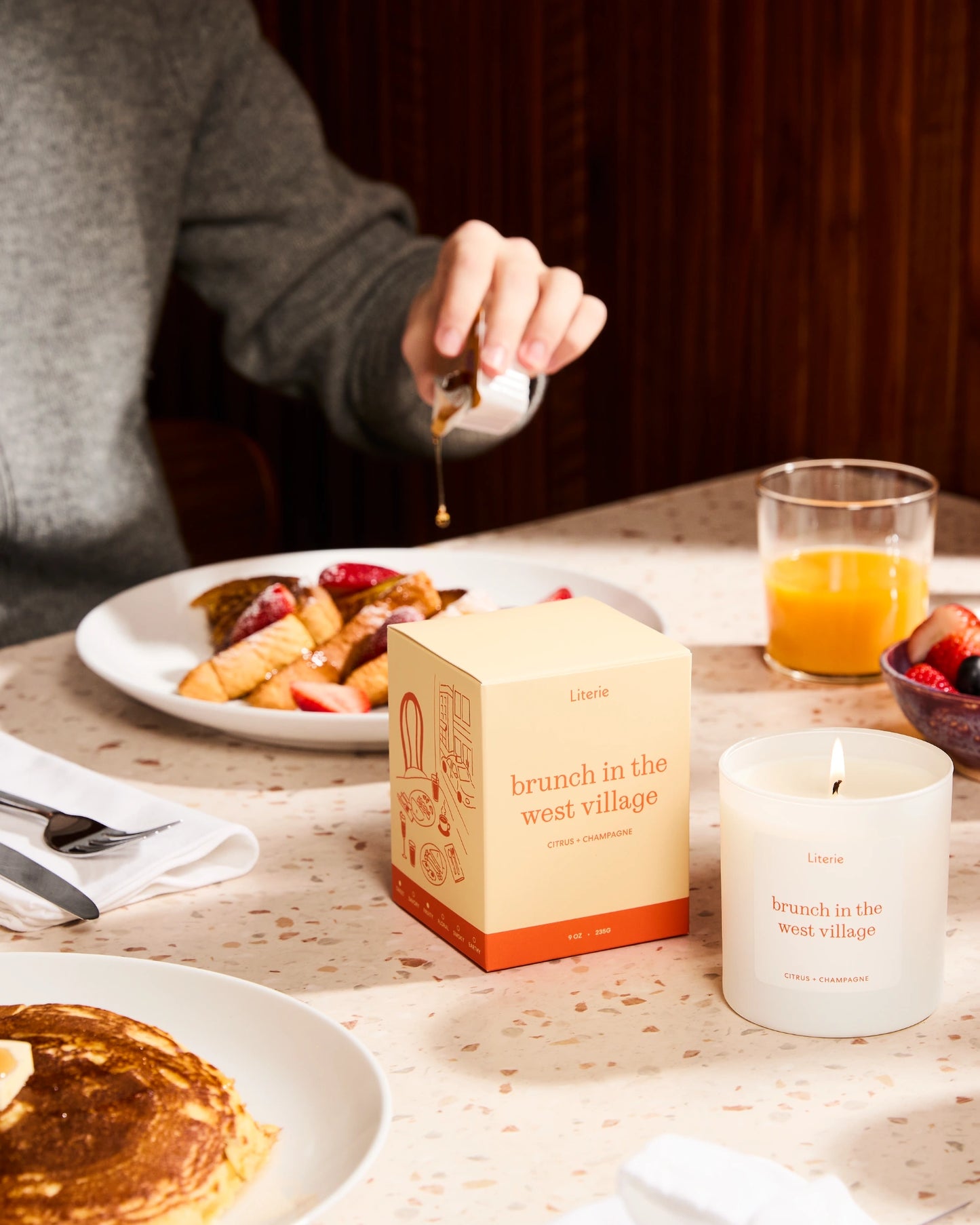 'Brunch in the West Village' box and candle and breakfast items on a table.