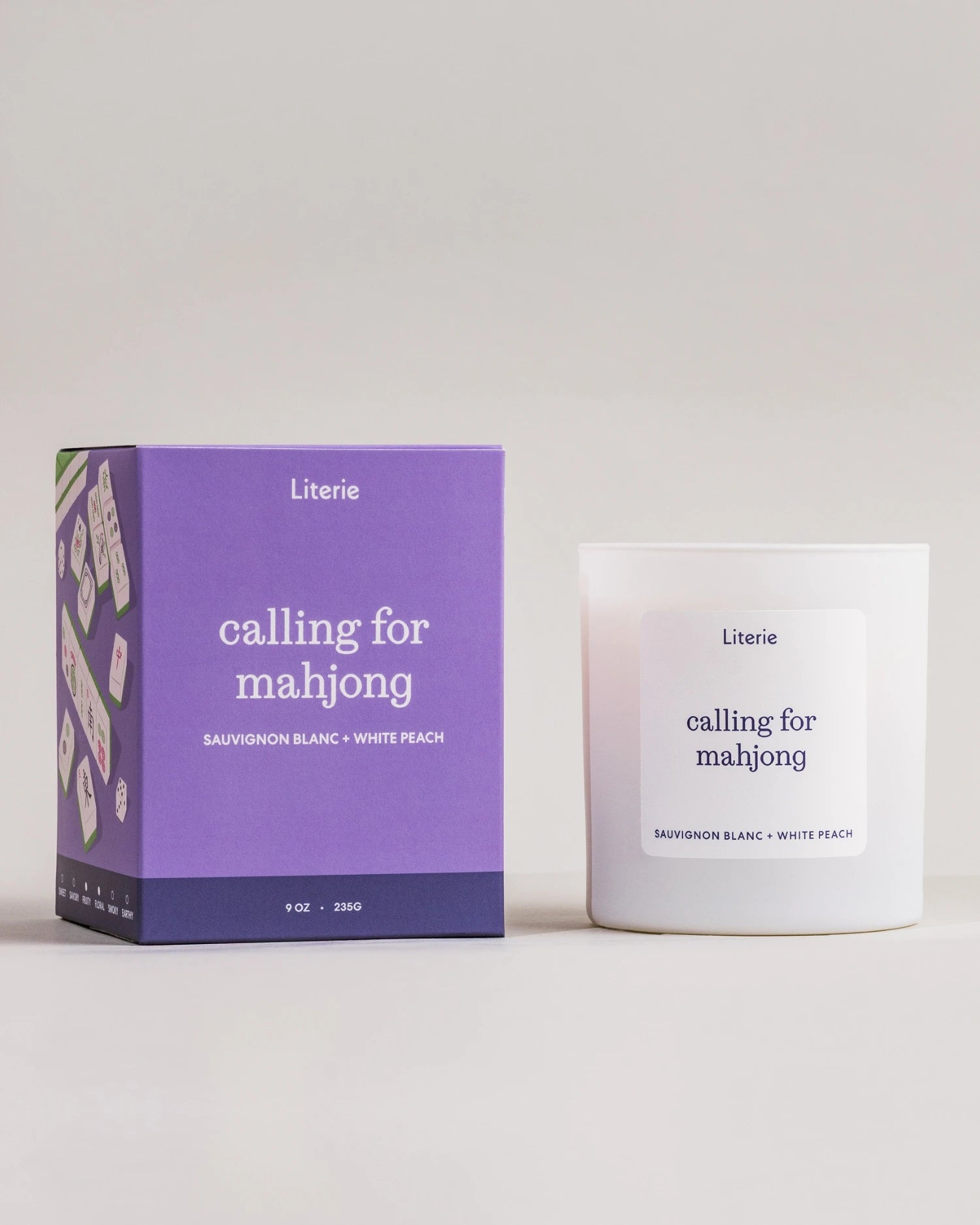 Literie ‘calling for mahjong’ candle and packaging with purple box on a light gray background