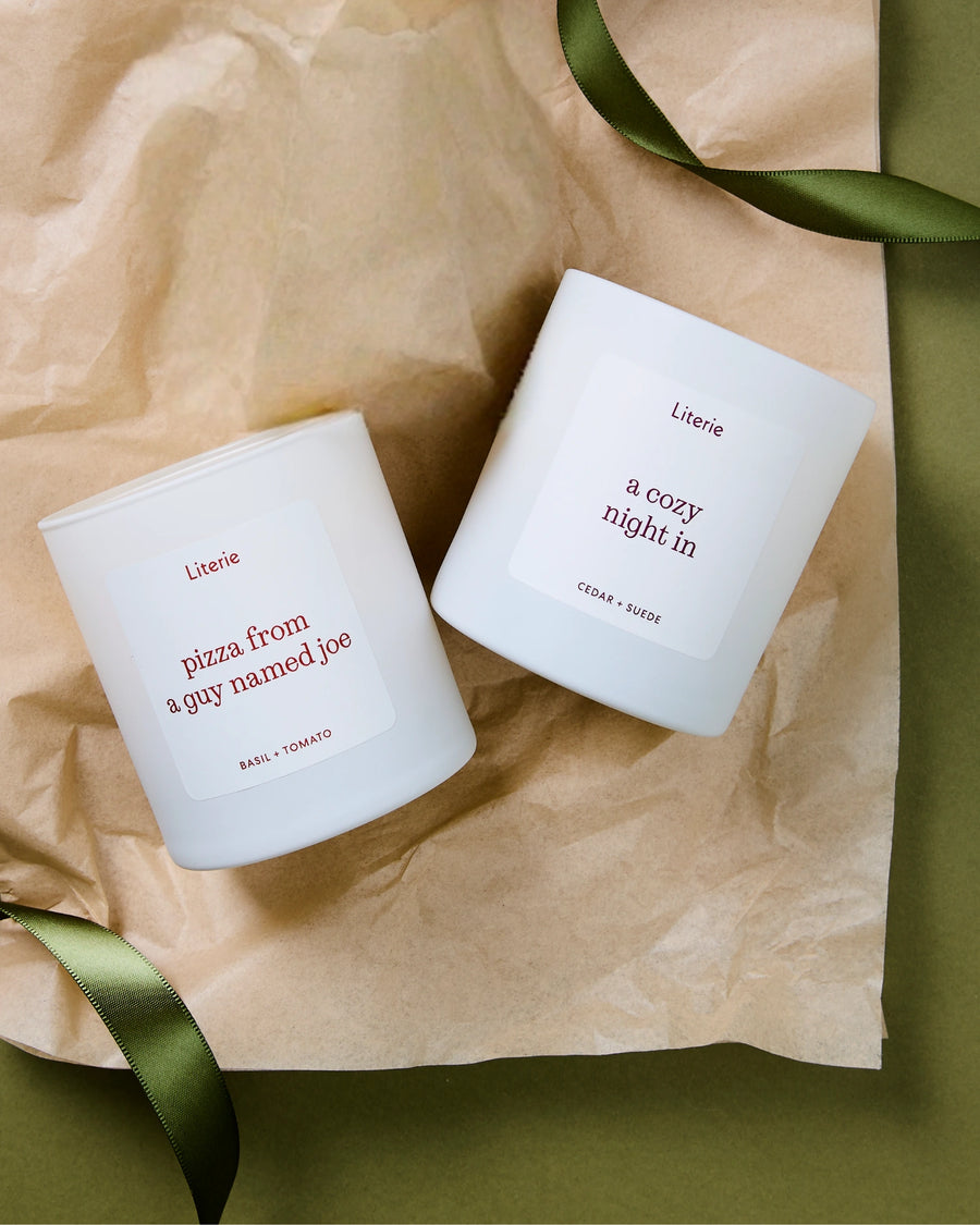 Two white candles with text on a brown tissue paper background