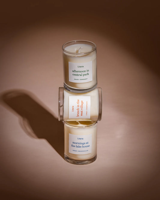 Three candles stacked on a brown background with labels on them