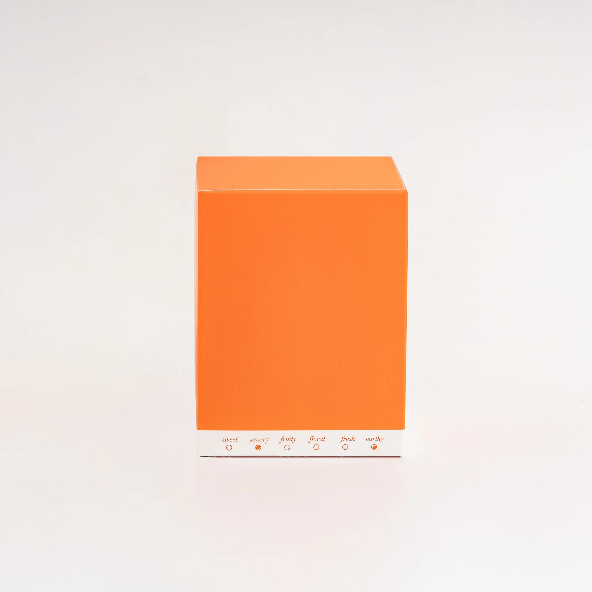 Orange box with scent swatches on a light gray background