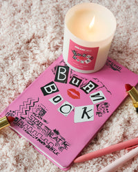 Burn Book Mean Girls candle on top of the actual Burn Book.