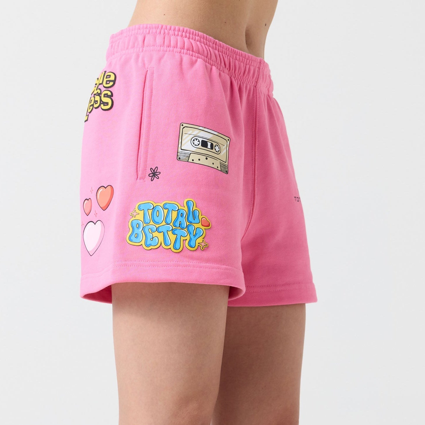 Person wearing pink Clueless by Samii Ryan shorts with colorful designs on a white background