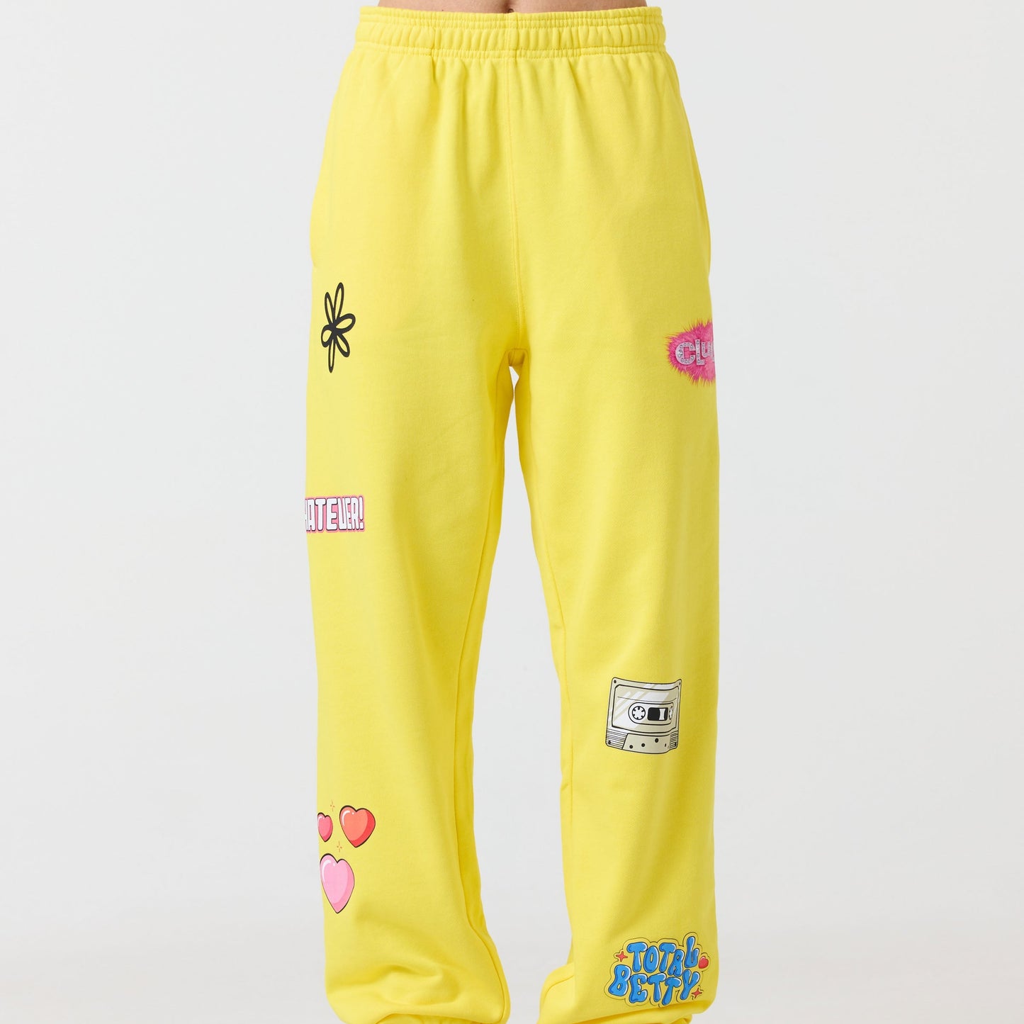 Yellow sweatpants with various patches on a white background