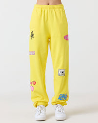 Yellow sweatpants with various patches on a white background