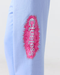 Light blue Clueless sweat pants with pink fur and rhinestone design on a plain background