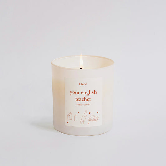 Candle that says your english teacher on it in orange.