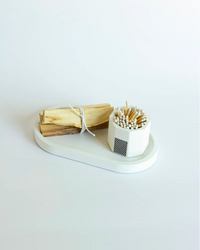 White tray with smudge and a container of matches on a white background