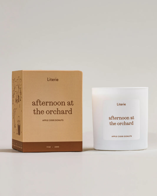 Candle and packaging of 'afternoon at the orchard' by Literie on a light background