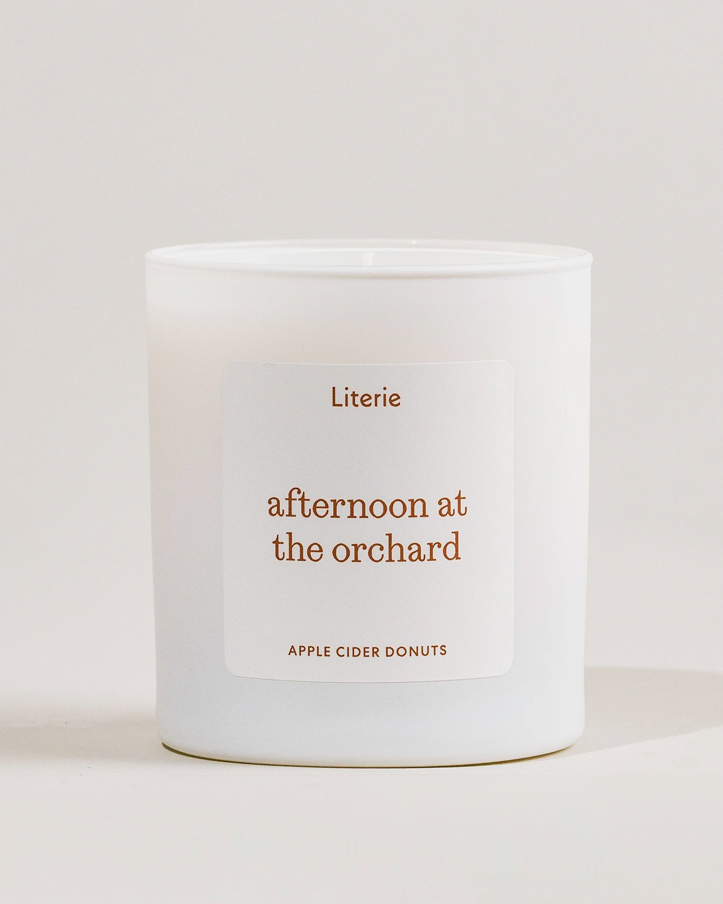 White candle called 'afternoon at. the orchard' with 'Literie' label on a light gray background