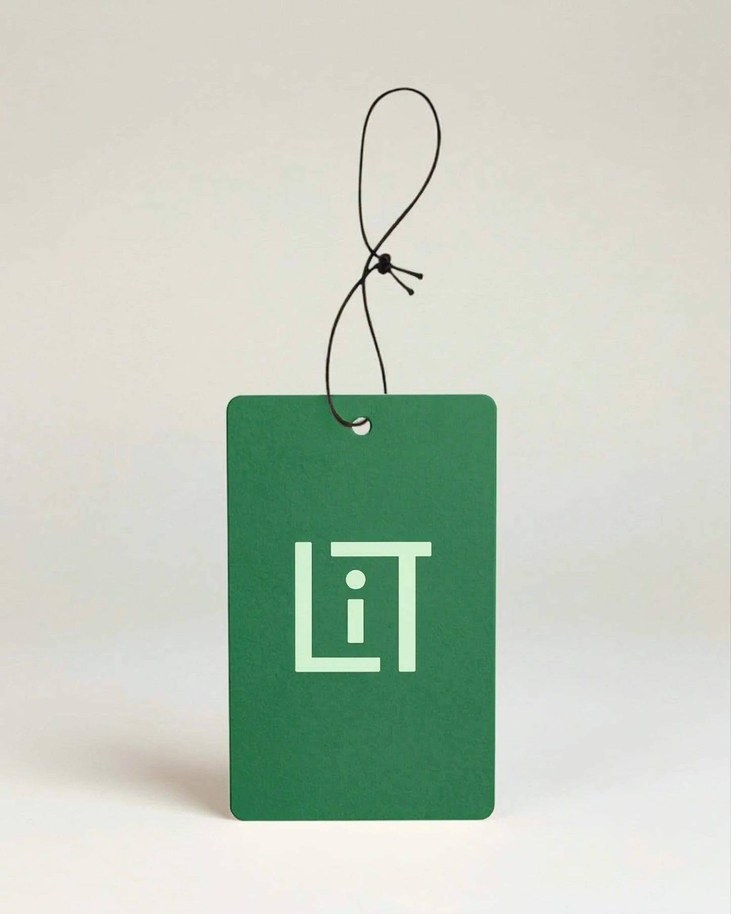 Green air freshener with the light green Literie monogram on a beige background