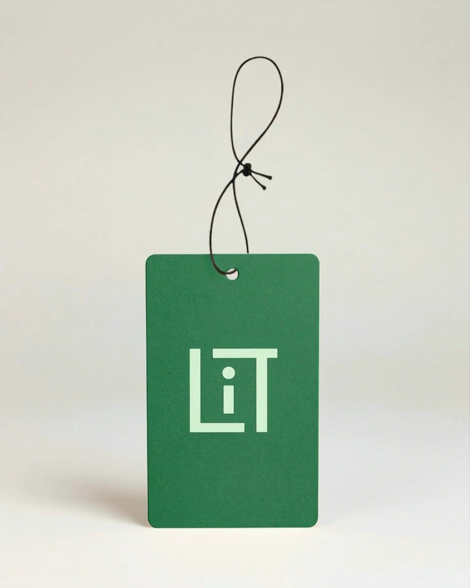 Green air freshener with the light green Literie monogram on a beige background