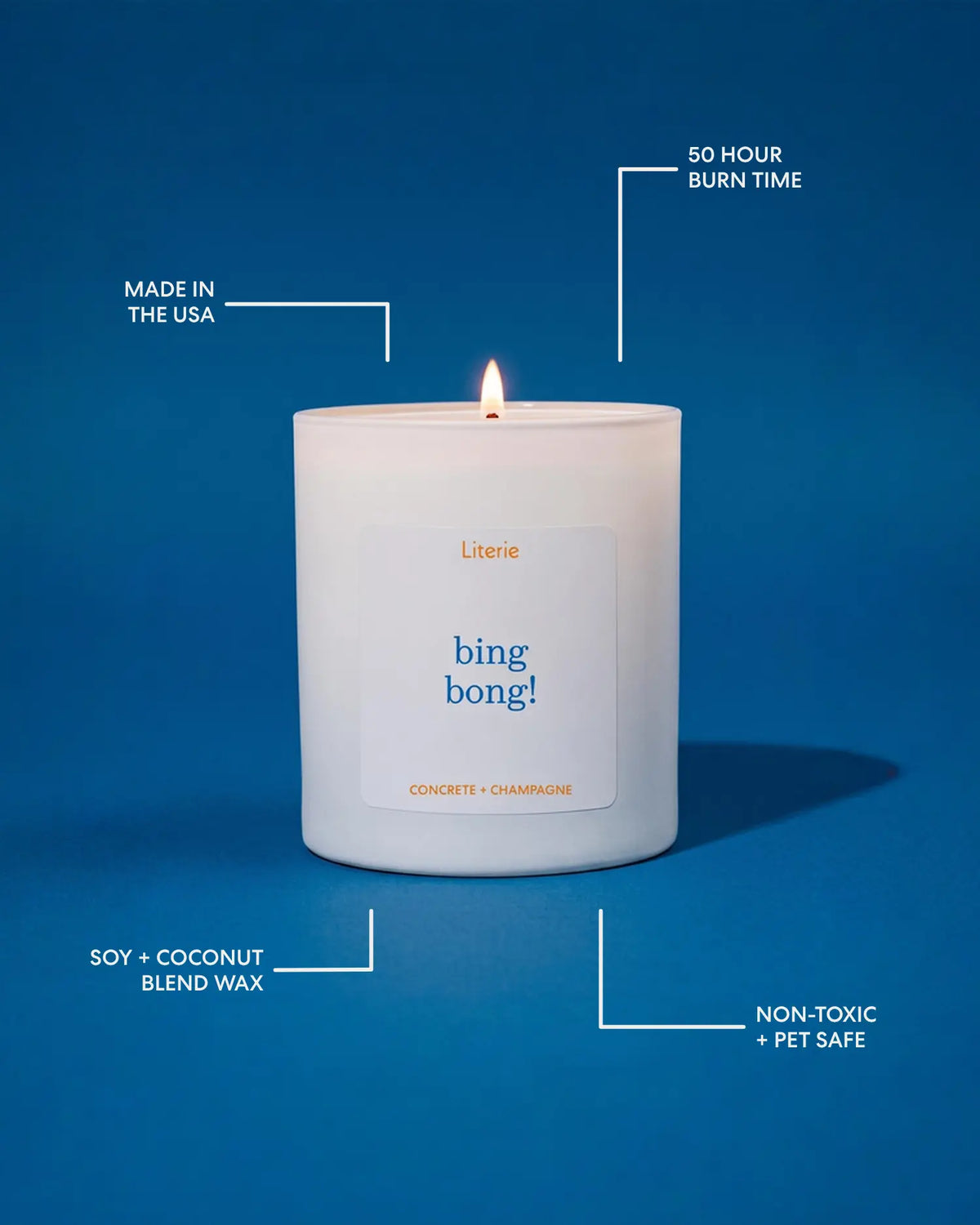 A lit white candle in a white glass jar on a blue background with callout lines and text highlighting product features: 'Made in the USA,' '50 Hour Burn Time,' 'Soy + Coconut Blend Wax,' and 'Non-Toxic + Pet Safe.' The front label reads 'Literie' and 'bing bong!' with 'Concrete + Champagne' below.
