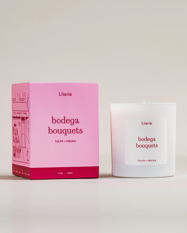 Pink box and white Literie candle labeled 'bodega bouquets' on a light background