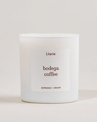 White candle with 'bodega coffee' label from Literie on a light gray background