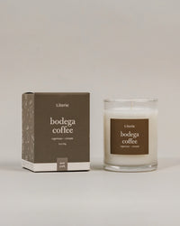A Literie bodega coffee 2.5oz scented candle in a clear glass jar next to its brown cardboard packaging box, set against a neutral light gray background.
