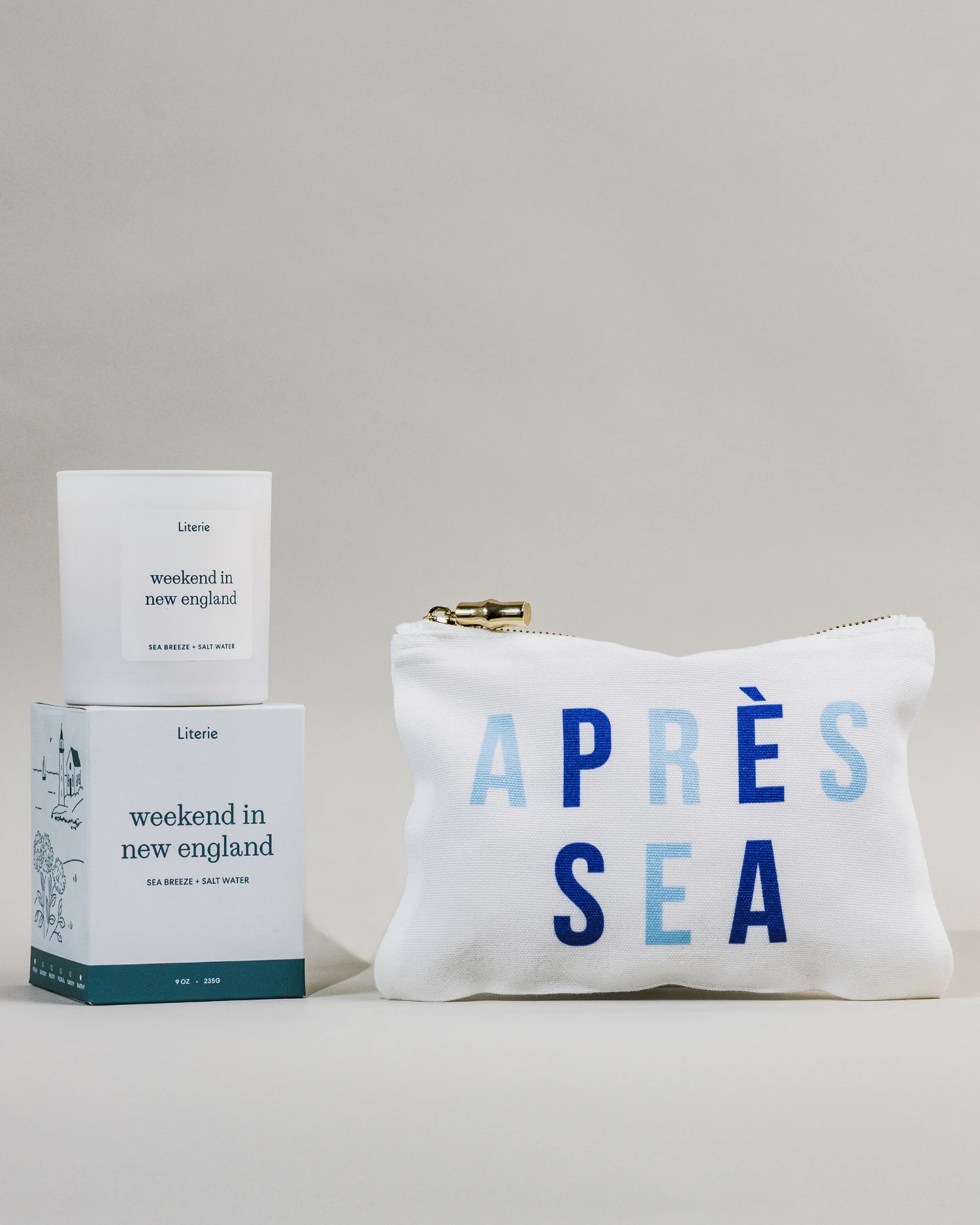White pouch with 'Après Sea' text,  'weekend in new england' candle and candle box on a light gray background