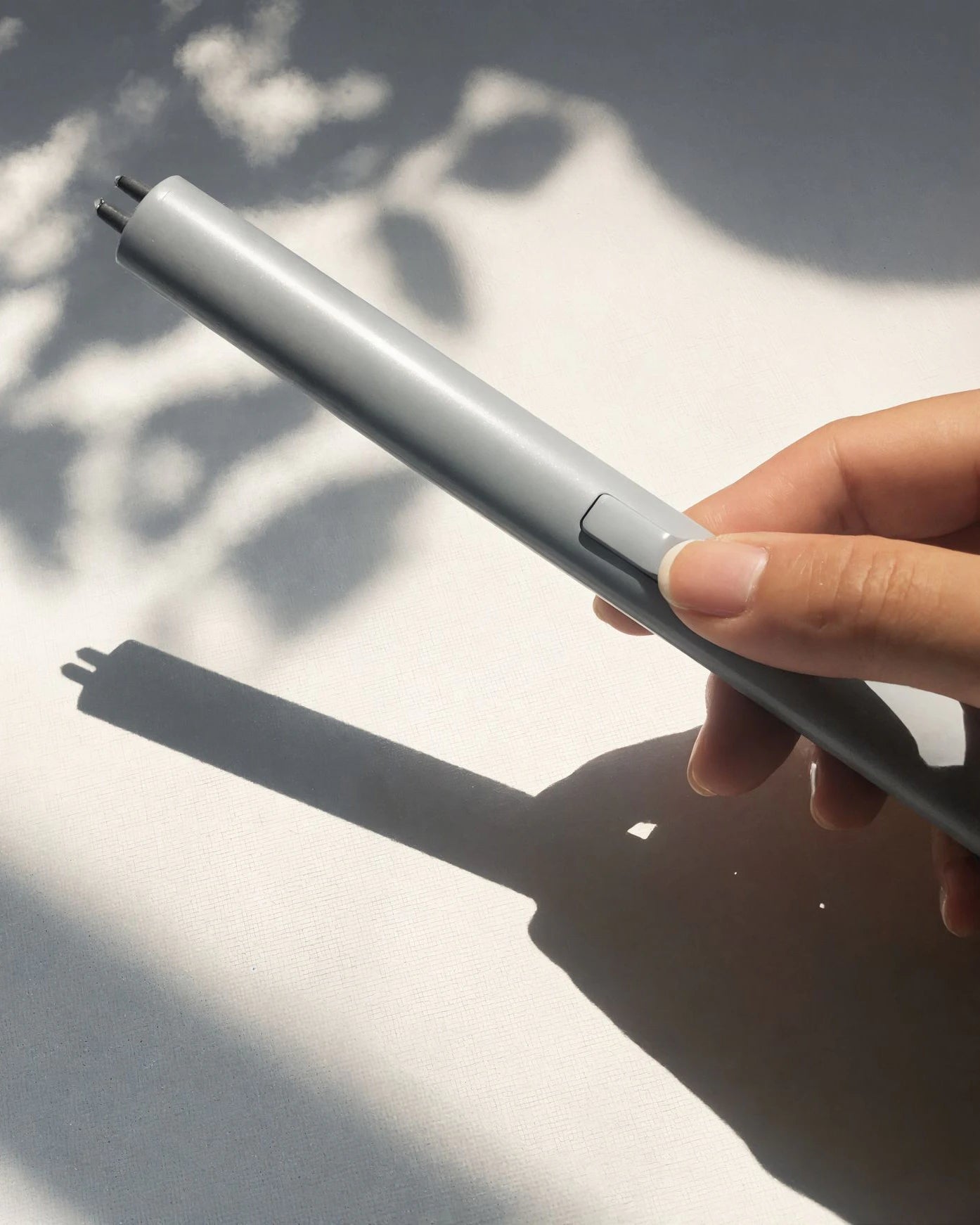Hand holding a silver lighter with a blurred background