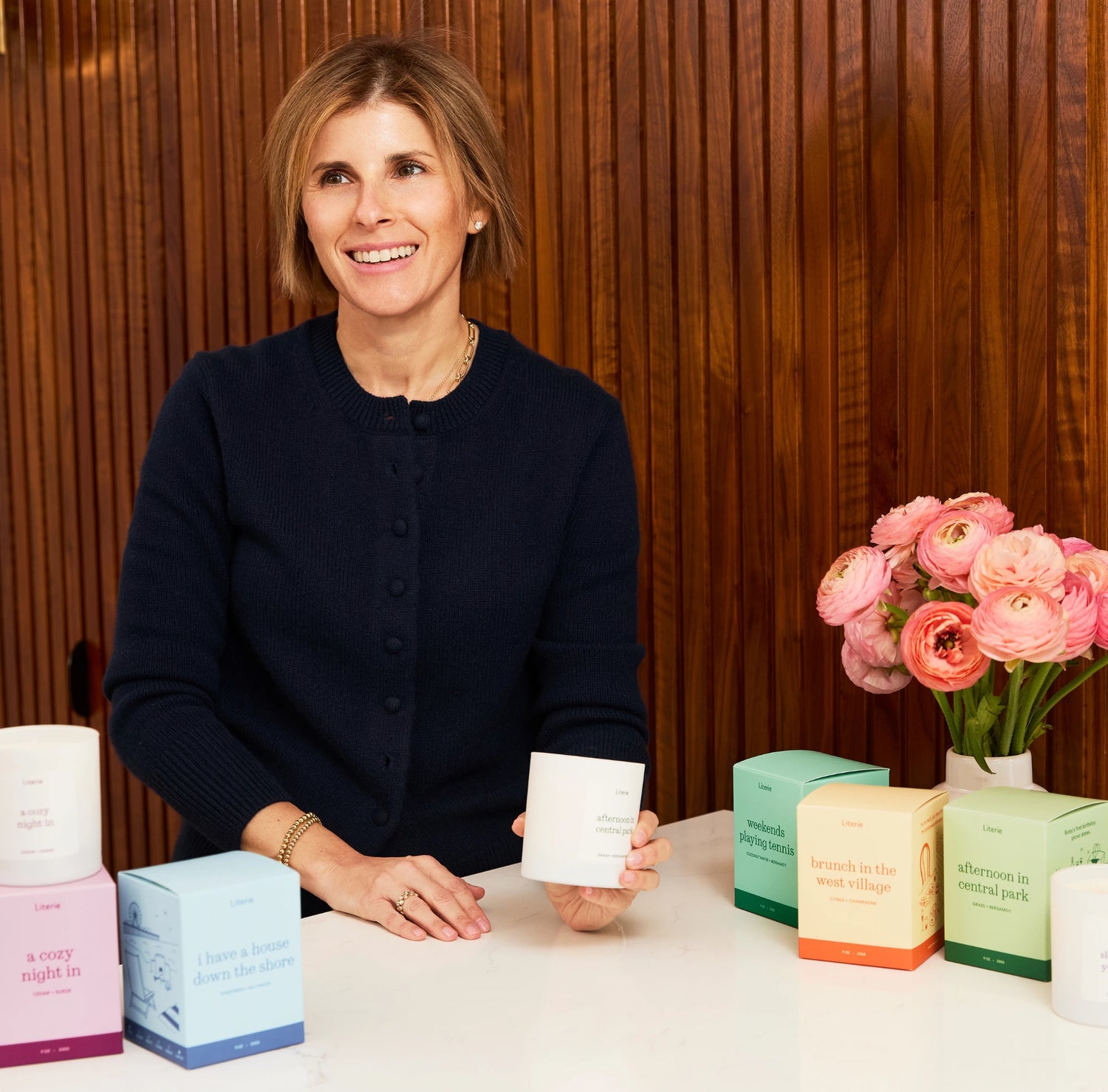 Erica Werber, Founder and CEO of Literie, behind a table with candles against a wooden background.
