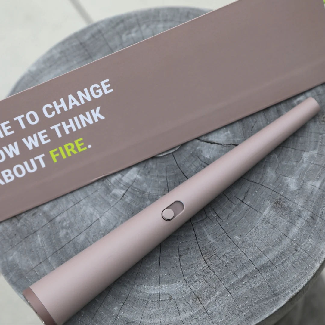 Pink lighter on a wooden surface with a motivational quote on a card.