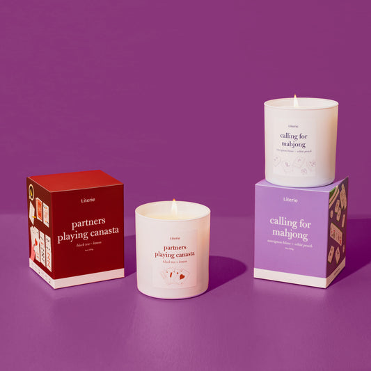 partners playing canasta candle an calling for mahjong candle on a purple background.