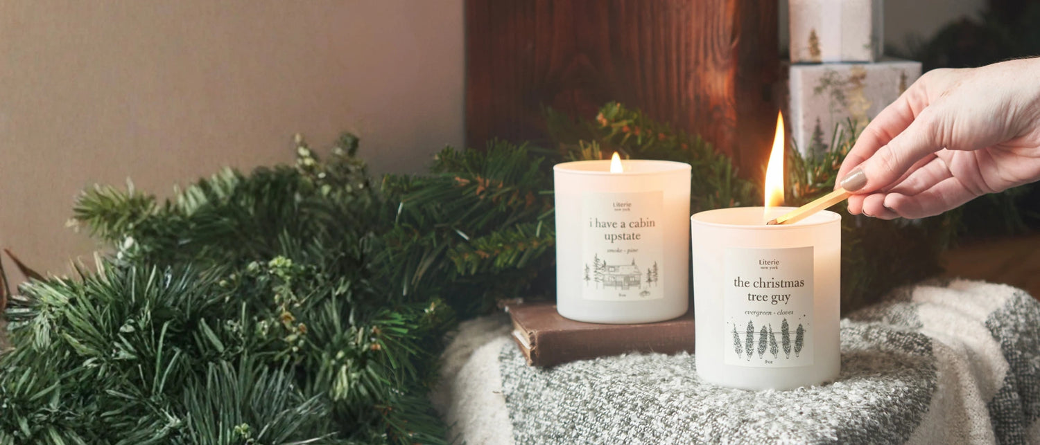 Candle being lit with greenery and a textured surface in the background