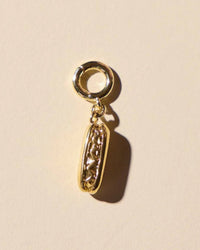 Hotdog 14 karat gold plated charm for jewelry in tan background.