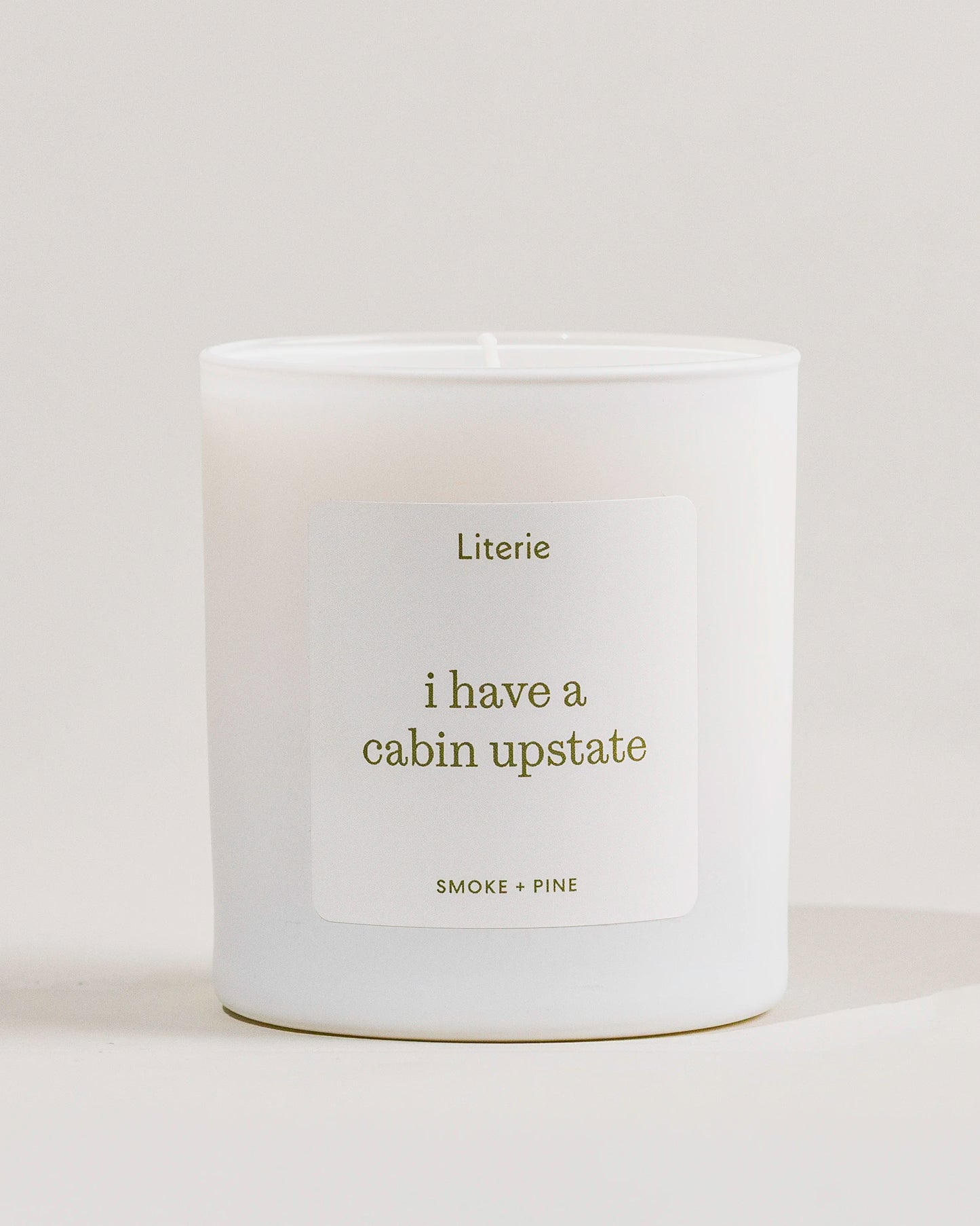 White 'i have a cabin upstate'c andle with a label on a light gray background