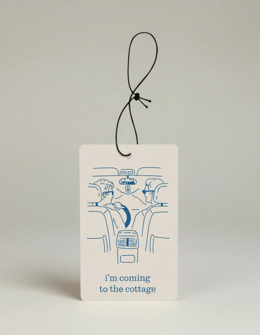 Card with line drawing of a car and text 'I'm coming to the cottage' on a beige background