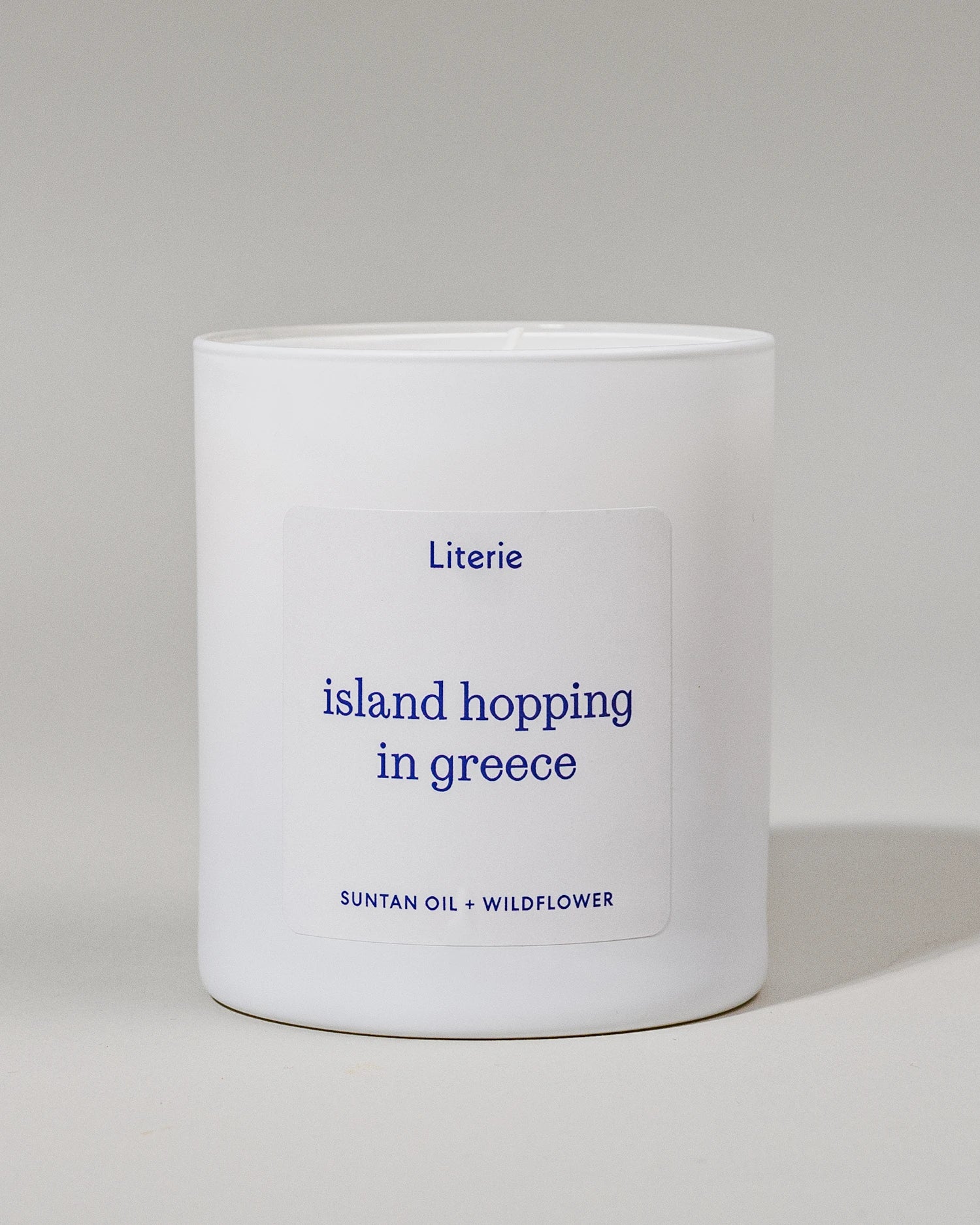 "Island Hopping in Greece" candle with a gray background.