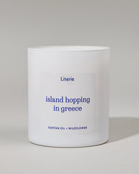"Island Hopping in Greece" candle with a gray background.