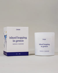 Literie candle and packaging with 'island hopping in greece' text on a neutral background.