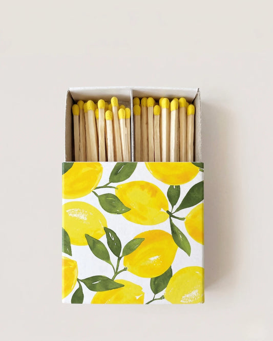 Matches with yellow tips in a box featuring lemon design on a light gray background