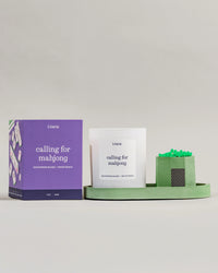Literie 'calling for mahjong' candle on a matcha green tray with matches on a gray background